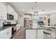 Open kitchen boasts granite countertops, stainless steel appliances, white cabinets, and seamless flow into the living area at 22714 N Chase Dr, Maricopa, AZ 85138