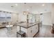 Spacious kitchen features a granite island with bar seating, stainless steel appliances, and seamless flow into the living area at 22714 N Chase Dr, Maricopa, AZ 85138