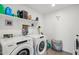 Functional laundry room with modern washer and dryer, shelving, and essential supplies at 22714 N Chase Dr, Maricopa, AZ 85138