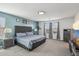 Spacious main bedroom with a tufted headboard, a sitting area, and natural light from the windows at 22714 N Chase Dr, Maricopa, AZ 85138