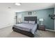 Comfortable main bedroom with gray upholstered bed, side tables with lamps, and minimalist décor at 22714 N Chase Dr, Maricopa, AZ 85138