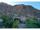 Stunning aerial view of desert home nestled at the base of rocky mountains with lush green landscaping at 25572 N 113Th Way, Scottsdale, AZ 85255