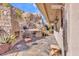 An outdoor dining area with a built-in barbecue and fireplace against a backdrop of desert rocks at 25572 N 113Th Way, Scottsdale, AZ 85255