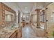 A luxury bathroom features dual vanities, columns, travertine tile, and an elevated tub at 25572 N 113Th Way, Scottsdale, AZ 85255