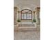 A bathtub on a raised platform surrounded by columns, statues, and elegant tile work at 25572 N 113Th Way, Scottsdale, AZ 85255