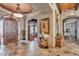 Elegant foyer with arched doorways, stone floors, and view to a fireplace at 25572 N 113Th Way, Scottsdale, AZ 85255