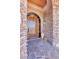 Elegant stone entryway features an arched wood door and custom stonework at 25572 N 113Th Way, Scottsdale, AZ 85255