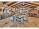 Sophisticated living room featuring stone fireplace, wood beam ceiling, and backyard views at 25572 N 113Th Way, Scottsdale, AZ 85255