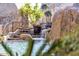 Stunning waterfall feature cascades into the pool, creating a serene oasis at 25572 N 113Th Way, Scottsdale, AZ 85255