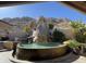 Unique backyard oasis with a rock waterfall feature cascading into a custom-designed pool at 25572 N 113Th Way, Scottsdale, AZ 85255