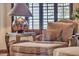 A close up of a sitting area with accent chair, ottoman, lamp, and window with decorative design at 25572 N 113Th Way, Scottsdale, AZ 85255