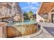 A stunning backyard pool with a unique rock waterfall feature overlooking a natural desert setting at 25572 N 113Th Way, Scottsdale, AZ 85255