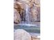 Close-up of a rock waterfall feature flowing into a pool, perfect for relaxation and ambiance at 25572 N 113Th Way, Scottsdale, AZ 85255