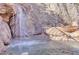 Beautiful rock waterfall cascading into a pool, creating a serene backyard oasis at 25572 N 113Th Way, Scottsdale, AZ 85255