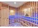 Custom wine cellar with built-in wooden storage racks and unique accent lighting at 25572 N 113Th Way, Scottsdale, AZ 85255