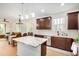 Modern kitchen with dark cabinets, stainless steel appliances, and an eat-in island open to the dining area at 300 N Gila Springs Blvd # 160, Chandler, AZ 85226
