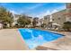 Community pool with lounge chairs and umbrellas, surrounded by modern residential buildings at 300 N Gila Springs Blvd # 160, Chandler, AZ 85226