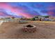 Spacious backyard featuring a brick fire pit, trampoline, white fence and two-story home at 31301 N Sunflower Way, San Tan Valley, AZ 85143