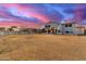 Spacious backyard with a white fence, lawn, and a two-story home with string lights at dusk at 31301 N Sunflower Way, San Tan Valley, AZ 85143