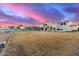 Expansive backyard featuring a white fence, lawn, and a two-story home with string lights at sunset at 31301 N Sunflower Way, San Tan Valley, AZ 85143