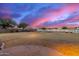 Expansive backyard featuring drought-tolerant landscaping and white fencing at dusk at 31301 N Sunflower Way, San Tan Valley, AZ 85143