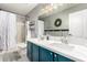 Charming bathroom featuring a double vanity with blue cabinets and decorative wall art at 31301 N Sunflower Way, San Tan Valley, AZ 85143
