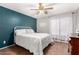 Well-lit bedroom featuring a modern ceiling fan, a comfortable bed, and a soothing teal accent wall at 31301 N Sunflower Way, San Tan Valley, AZ 85143