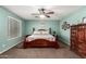 Primary bedroom featuring a wooden bed frame, two windows, and an installed ceiling fan at 31301 N Sunflower Way, San Tan Valley, AZ 85143