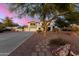 Spacious two-story home with a three-car garage, desert landscaping, and a circular driveway at dusk at 31301 N Sunflower Way, San Tan Valley, AZ 85143