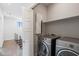 Laundry room with stainless steel washer and dryer, overhead storage and tile flooring at 3233 N 70Th St # 1006, Scottsdale, AZ 85251
