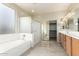 The spacious bathroom has a soaking tub, glass shower, and double vanity at 3663 S Soho Ln, Chandler, AZ 85286