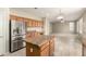Open kitchen with island, wood cabinetry, and stainless steel refrigerator overlooks living area at 3663 S Soho Ln, Chandler, AZ 85286