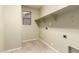 The neutral laundry room has tiled floors, shelf storage, and a window at 3663 S Soho Ln, Chandler, AZ 85286