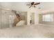 Open-concept living area with high ceilings, neutral carpeting, ceiling fan, and staircase at 3663 S Soho Ln, Chandler, AZ 85286
