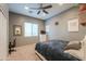 Cozy bedroom featuring carpet floor, ceiling fan and a mirror at 37262 W Oliveto Ave, Maricopa, AZ 85138