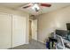 Bedroom with a ceiling fan and a closet, alongside a desk with a computer setup, creating a functional space at 3753 E Sebastian Ln, Gilbert, AZ 85297