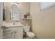 Cozy powder room featuring a decorative mirror, updated fixtures, and neutral decor at 3753 E Sebastian Ln, Gilbert, AZ 85297