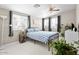 Bright bedroom featuring a queen bed, ceiling fan, white floors, and multiple windows with neutral-toned curtains at 3802 E Shaw Butte Dr, Phoenix, AZ 85028
