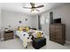 Cozy bedroom featuring a ceiling fan, modern patterned bedding, dark-stained dresser, and windows at 3802 E Shaw Butte Dr, Phoenix, AZ 85028
