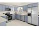 Well-equipped kitchen boasts blue cabinetry, stainless steel appliances, and ample counter space at 3802 E Shaw Butte Dr, Phoenix, AZ 85028