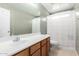 Bathroom featuring a large mirror, vanity with sink, and a shower with a privacy curtain at 45 S 238Th Dr, Buckeye, AZ 85396