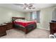 A carpeted main bedroom boasts a ceiling fan and large window for ample natural light at 45 S 238Th Dr, Buckeye, AZ 85396