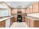 Simple kitchen with light wood cabinets, laminate countertops, and black appliances at 45 S 238Th Dr, Buckeye, AZ 85396
