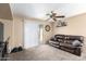 Cozy living room with plush carpeting, a comfortable leather sofa, and sliding glass doors to the patio at 45 S 238Th Dr, Buckeye, AZ 85396