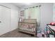 room featuring a crib, window for natural light, and decorative wall art at 45 S 238Th Dr, Buckeye, AZ 85396