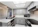 This kitchen is well-lit with white countertops, stainless steel appliances, grey cabinets and a view to the yard at 461 W Holmes -- # 342, Mesa, AZ 85210