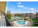 A view of the community pool, tennis courts, and grassy areas from an upper level balcony on a bright, sunny day at 461 W Holmes -- # 342, Mesa, AZ 85210