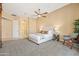 Spacious carpeted main bedroom with a ceiling fan, white trim, and modern furniture and decor at 4630 E Carriage Ct, Gilbert, AZ 85297