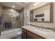 Stylish bathroom featuring granite counters, decorative mirror, and tiled shower-tub combination at 4637 E Fernwood Ct, Cave Creek, AZ 85331