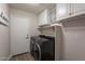 Well-organized laundry room with washer, dryer, overhead cabinets, and a door to the outside at 4637 E Fernwood Ct, Cave Creek, AZ 85331